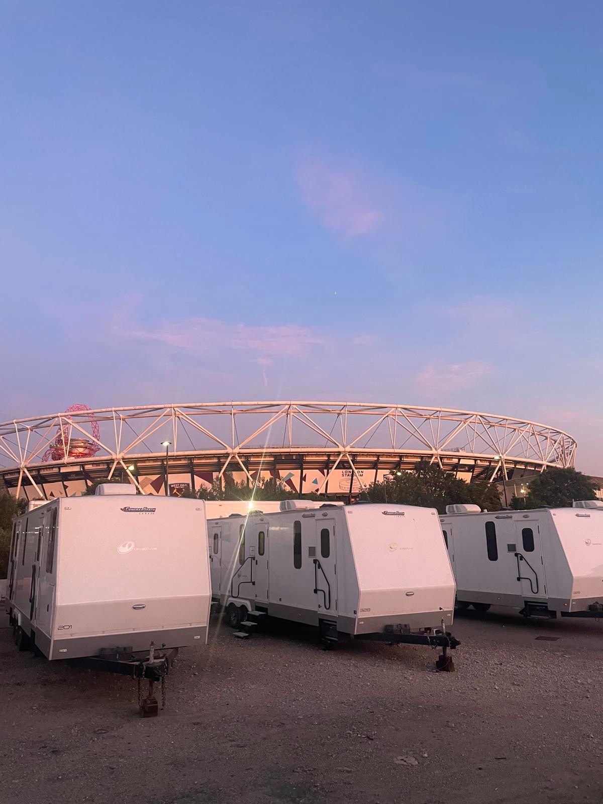 Artist trailers at unit base before sunrise, London Stadium behind